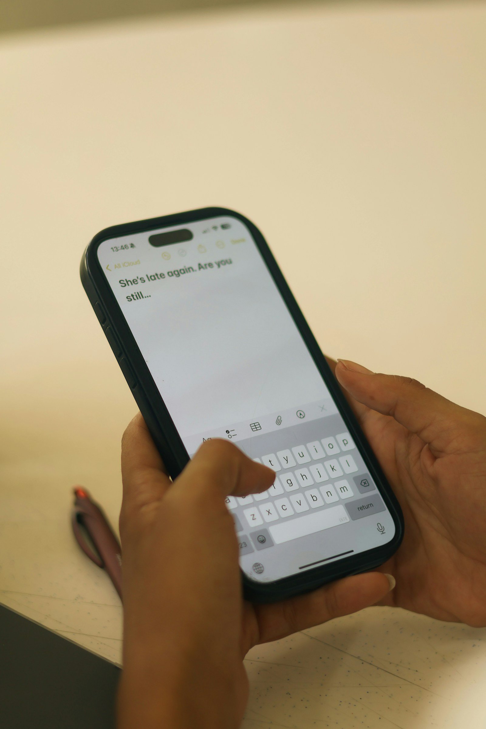 Hands holding a smartphone with an SMS on screen